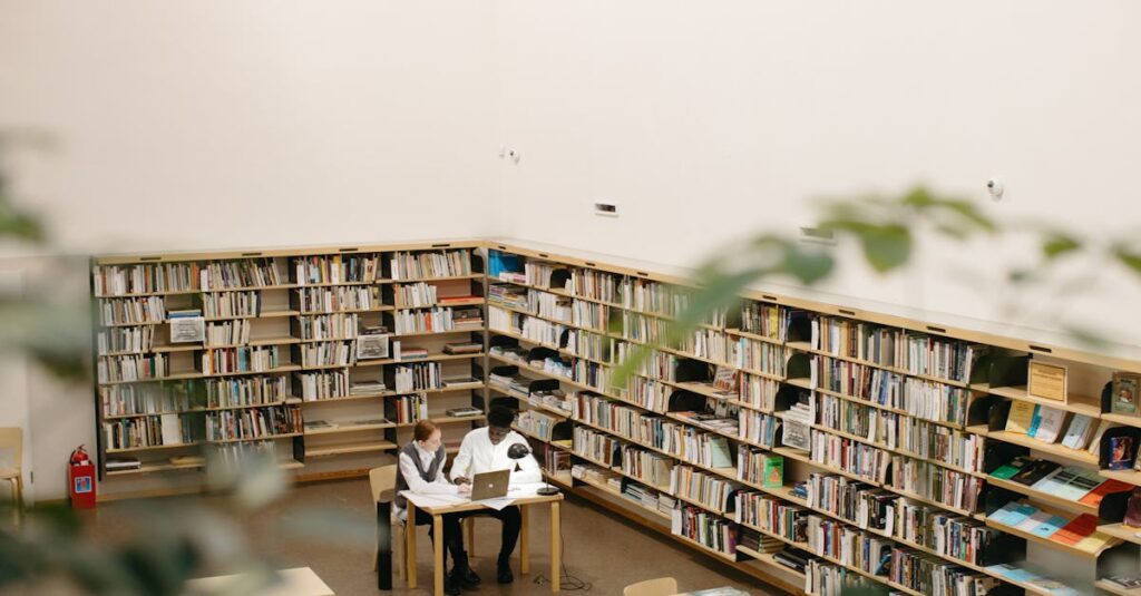 Students studying together at a library with laptops and books.