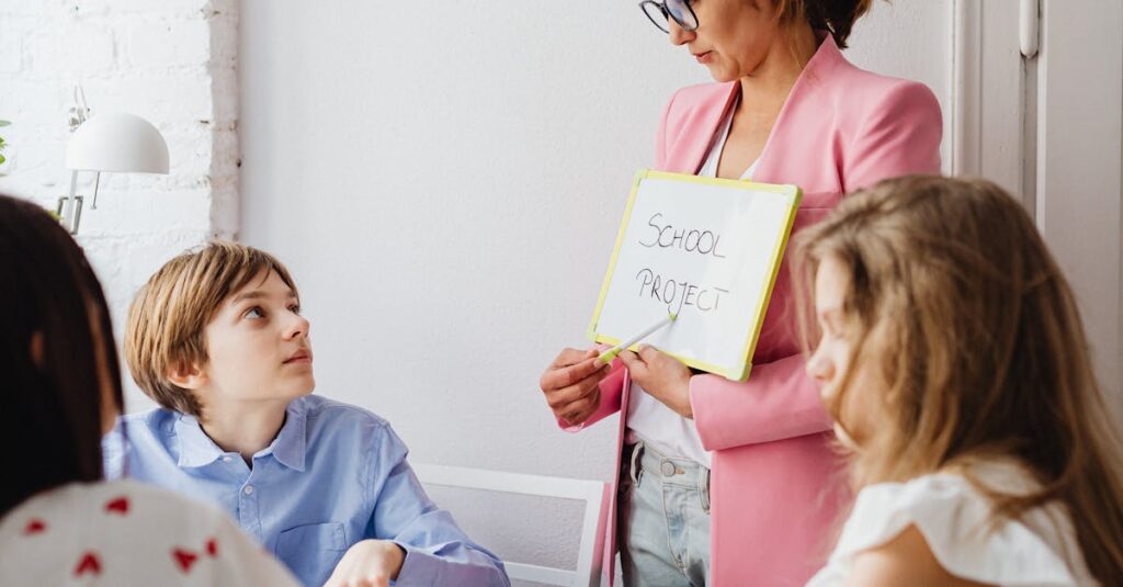 A teacher engages with students during a school project discussion using a whiteboard in a classroom.